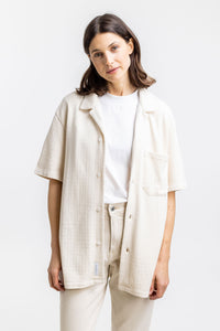 Das Frauen Model trägt das Rotholz Bowling Hemd aus Bio Baumwoll Strick in Off-White