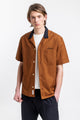 Das Männer Model trägt das Rotholz Bowling Shirt mit Kontrastkragen aus Bio-Baumwolle in Terracotta