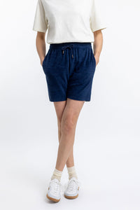Das Frauen Model trägt die Rotholz Frottee Shorts aus Bio Baumwolle in Blau