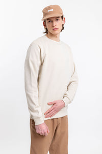 Männer Model trägt das Rotholz Logo Sweatshirt aus Bio-Baumwolle in Creme