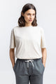 Frauen Model trägt das Rotholz Logo T-Shirt aus Bio Baumwolle in Creme