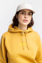 Frauen Model trägt den Rotholz Retro Logo Hoodie aus Bio-Baumwolle in Senfgelb