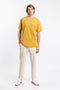 Das Männer Model trägt das Rotholz Retro Logo T-Shirt aus Bio-Baumwolle in Senfgelb