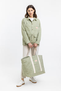 Das Frauen Model trägt die leichte Rotholz Jacke aus Bio Canvas in gruen Kariert